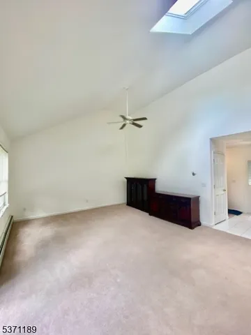 an empty room with ceiling fan and window