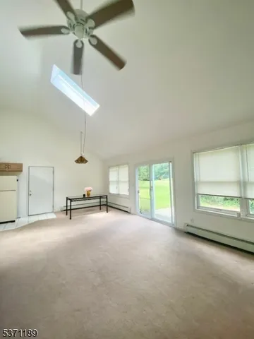 an empty room with windows and ceiling fan