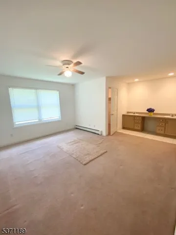 a view of a big room with windows and chandelier fan