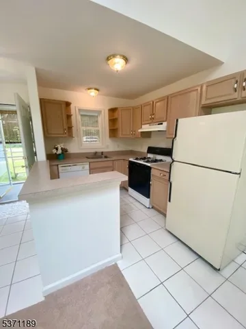 a kitchen with kitchen island a stove a refrigerator a sink and a stove
