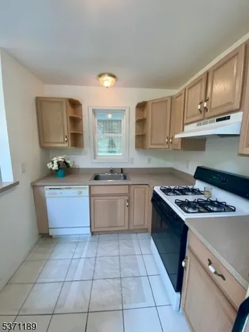 a kitchen with a stove sink and cabinets