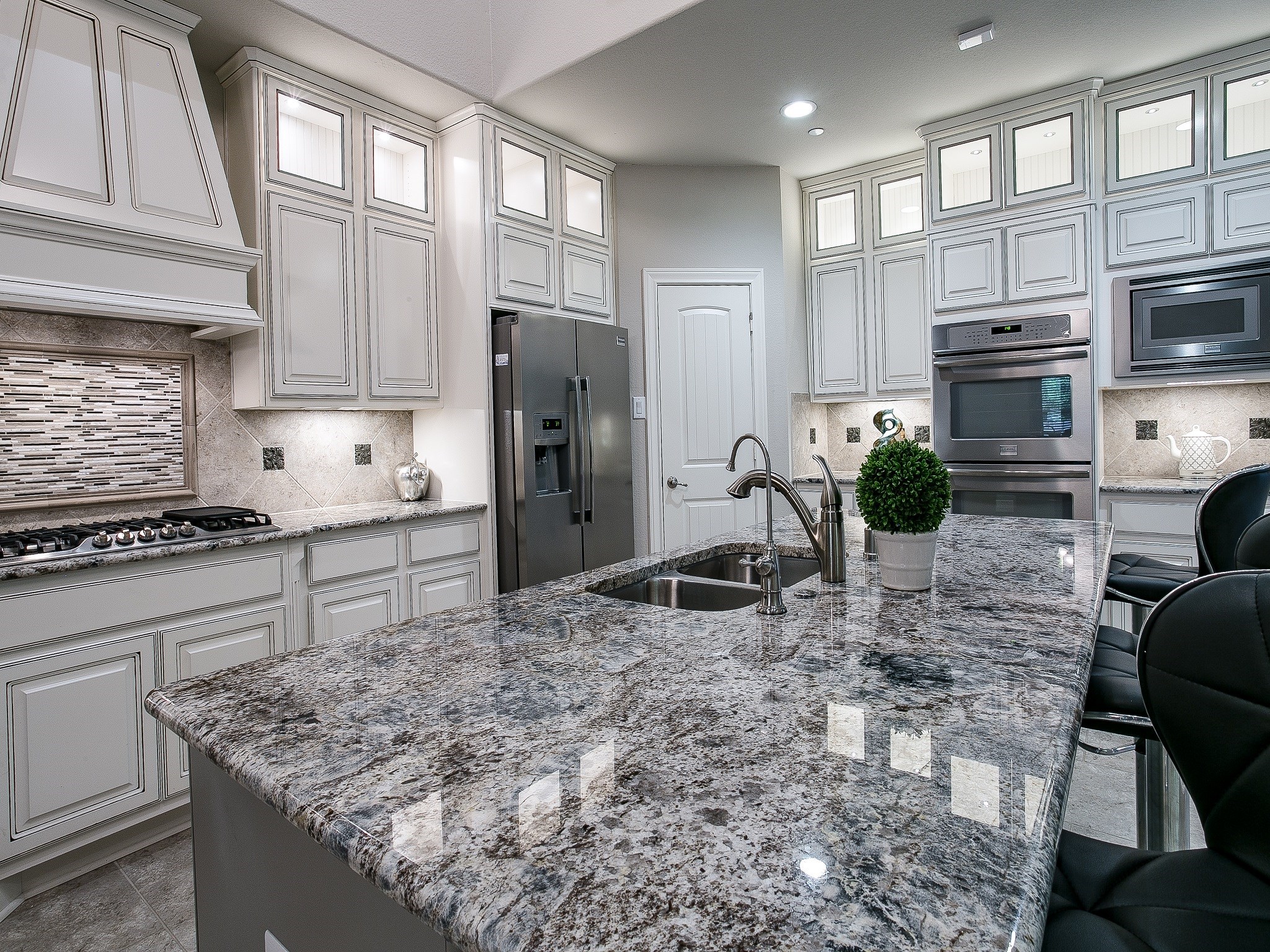 9018 Meacom Drive Conroe, TX 77384 - Photo 15 of 41 a kitchen with stainless steel appliances granite countertop a stove a refrigerator a sink a oven with white cabinets and wooden floor