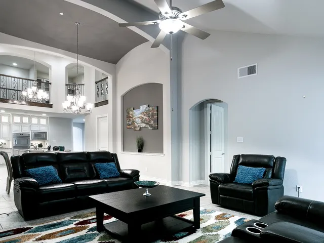 a living room with furniture and a chandelier