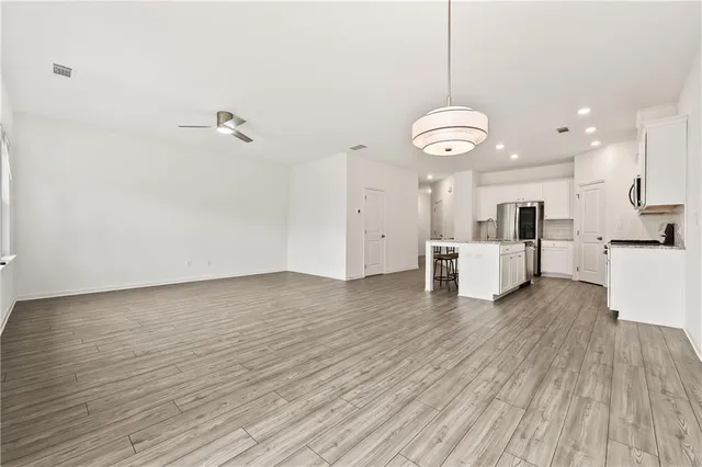 a view of a kitchen with wooden floor and window