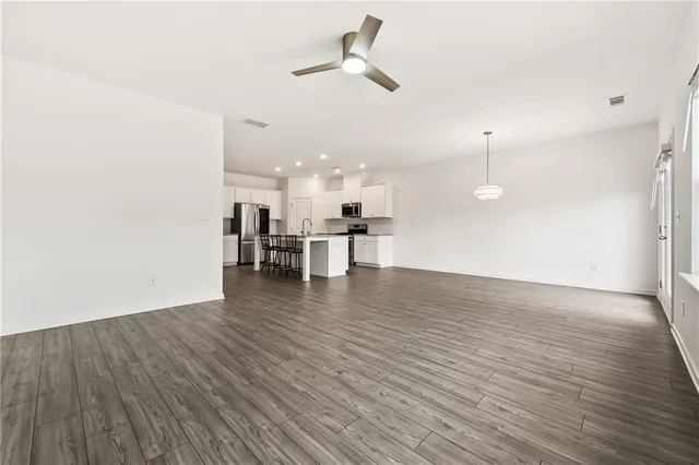 a view of a room with wooden floor and a ceiling fan