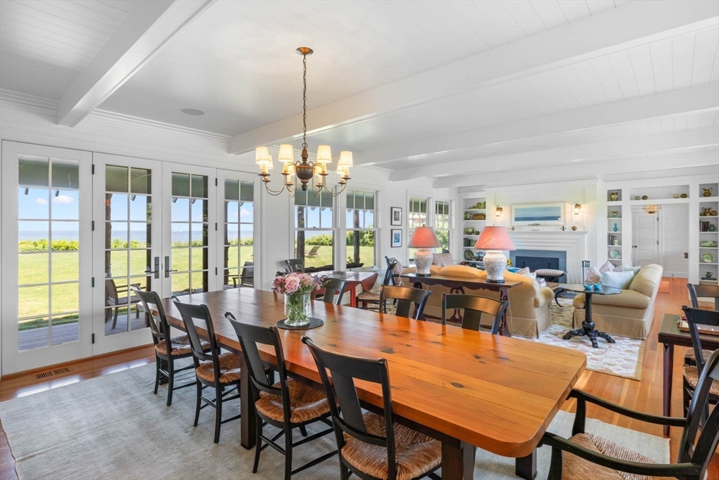 37 North Neck Road Edgartown, MA 02539 - Photo 11 of 40 a view of a dining room and livingroom with furniture wooden floor a chandelier