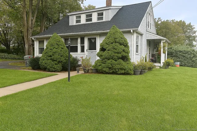 a front view of a house with a yard and trees