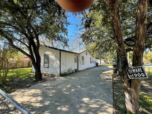 a view of a yard with plants and trees