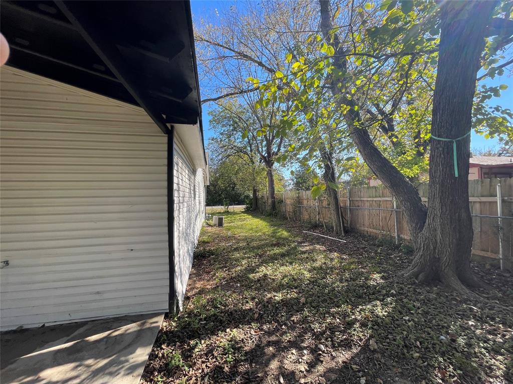 1041 Bradfield Road Dallas, TX 75217 - Photo 4 of 9 a view of a backyard with a tree