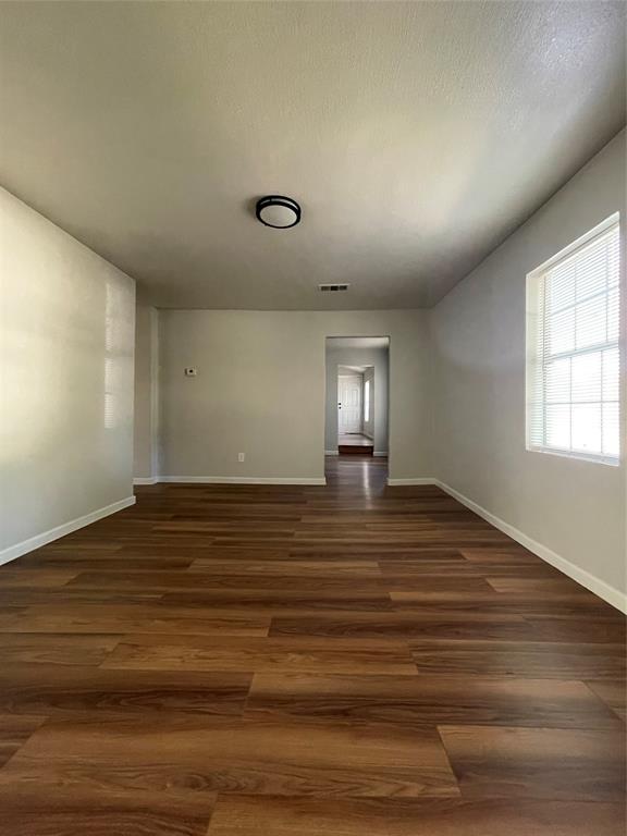 1041 Bradfield Road Dallas, TX 75217 - Photo 8 of 9 a view of empty room with window and wooden floor