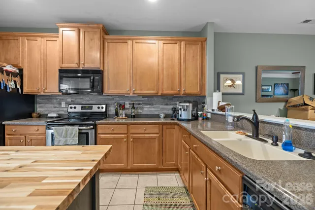 a kitchen with granite countertop a stove sink and cabinets