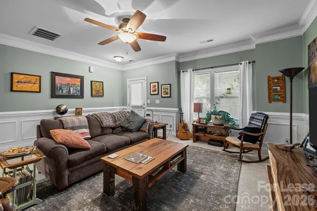 a living room with furniture a ceiling fan and a window