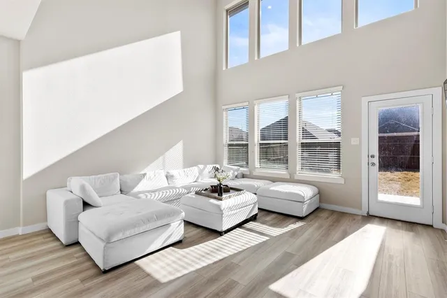 a living room with couches and a dining table with wooden floor