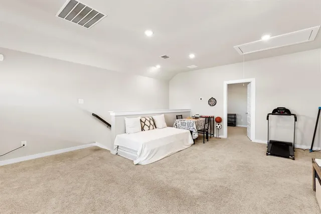 a spacious bedroom with a bed and a lamp