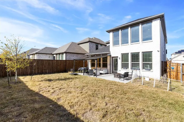 a view of a house with a patio and wooden fence