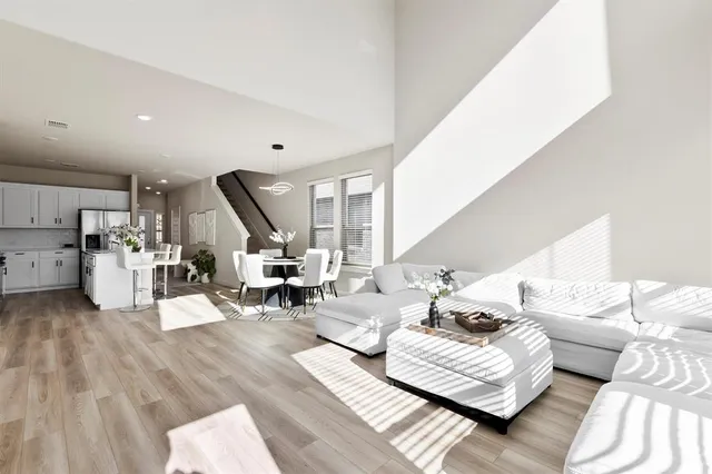 a living room with furniture and hard wood flooring