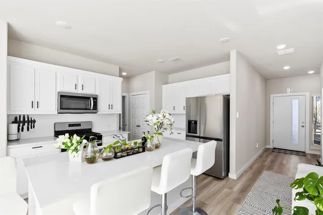 a view of a dining room with furniture a kitchen and chandelier