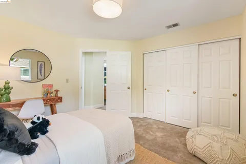 a bedroom with a bed and a painting on the wall