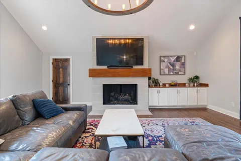 a living room with furniture a chandelier and a rug