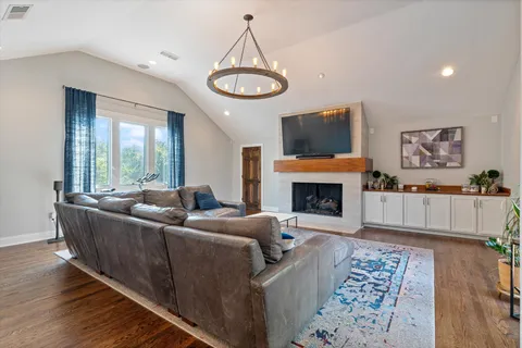 a living room with furniture a dining table and a chandelier