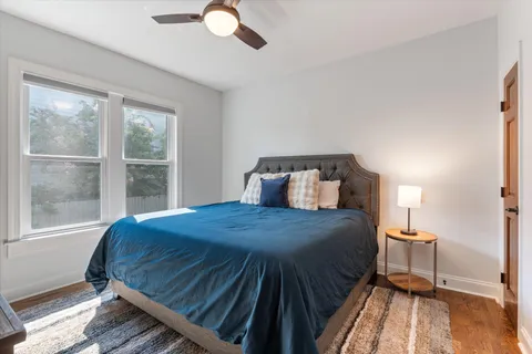 a bedroom with a bed a dresser and window
