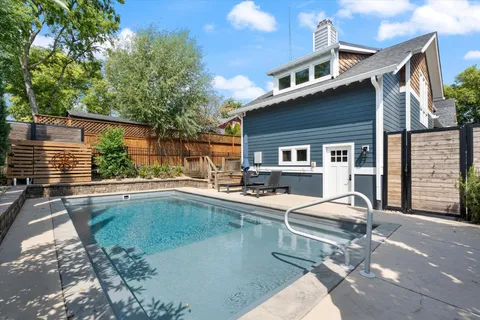 a dining room table chairs and a chandelier fan