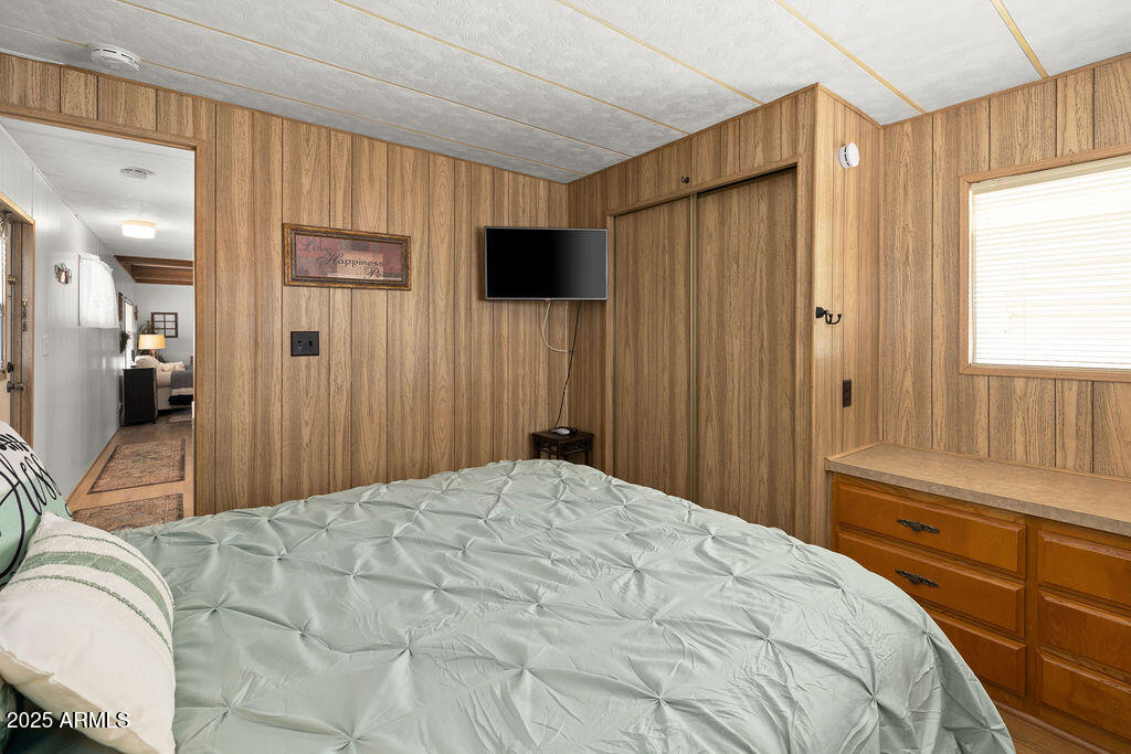 10220 East Apache Trail, Unit 16 Apache Junction, AZ 85120 - Photo 19 of 49 a bedroom with a bed a mirror on dresser and a window
