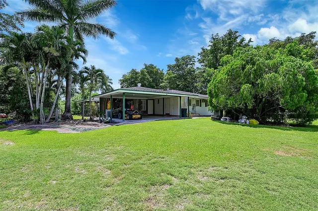 a view of a livingroom with furniture wooden floor and a kitchen