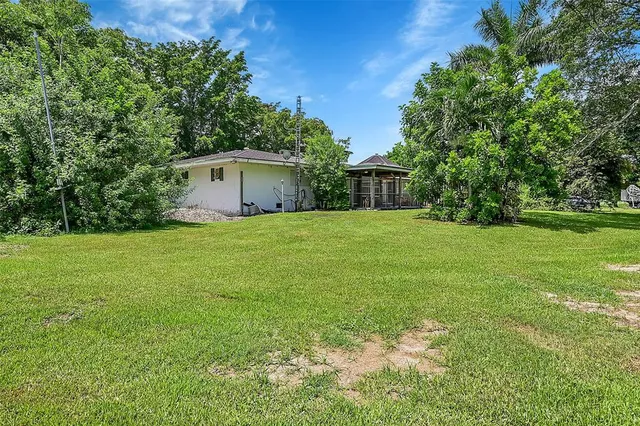 a dining room with wooden floor a chandelier a wooden table and chairs