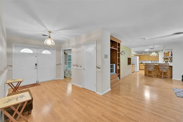 a kitchen with stainless steel appliances a refrigerator a sink dishwasher a oven and a dining table with wooden floor