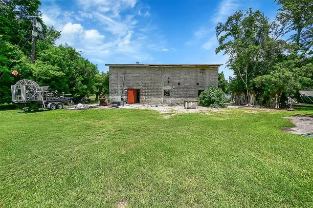 an aerial view of residential houses with outdoor space and trees