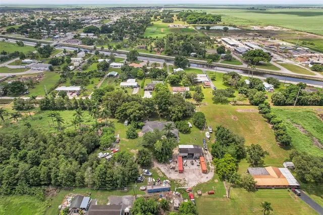 an aerial view of residential houses with outdoor space and trees