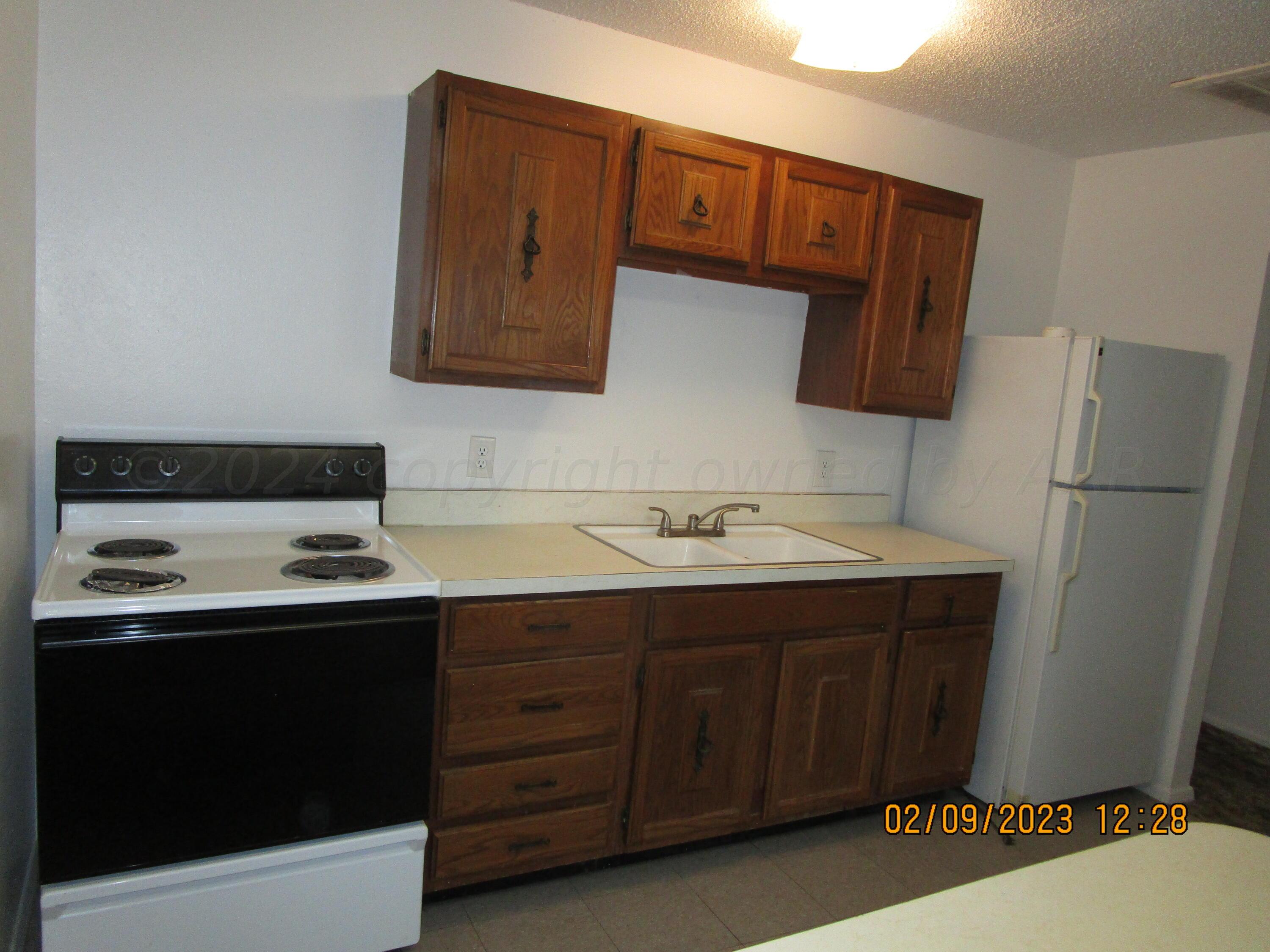 710 Deahl Street Borger, TX 79007 - Photo 3 of 5 a kitchen with a sink and a refrigerator