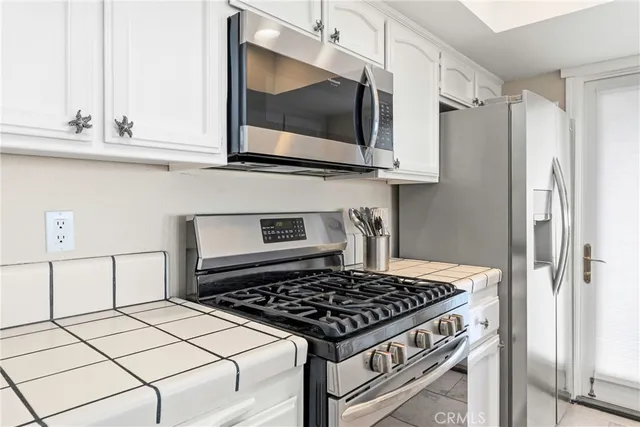 a large white kitchen with cabinets and furniture