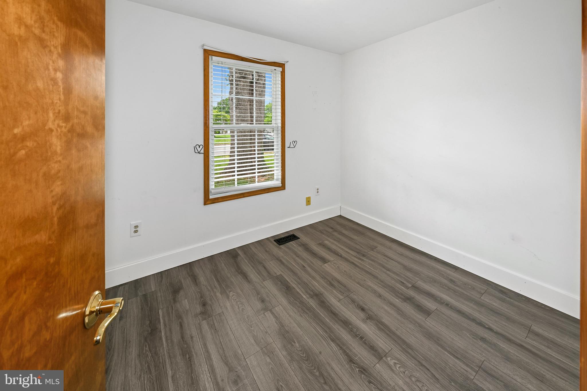 10303 Abbott Road Manassas, VA 20110 - Photo 20 of 36 a view of an empty room with wooden floor and a window