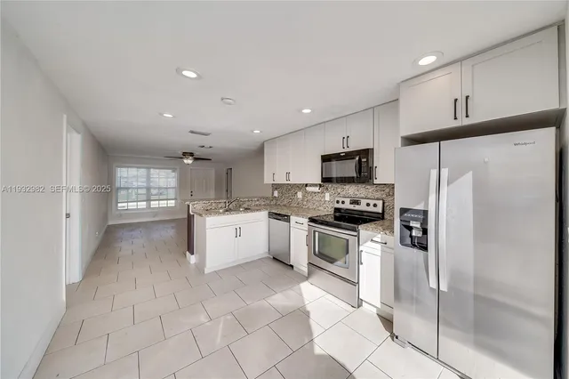 a kitchen with stainless steel appliances a refrigerator sink and microwave