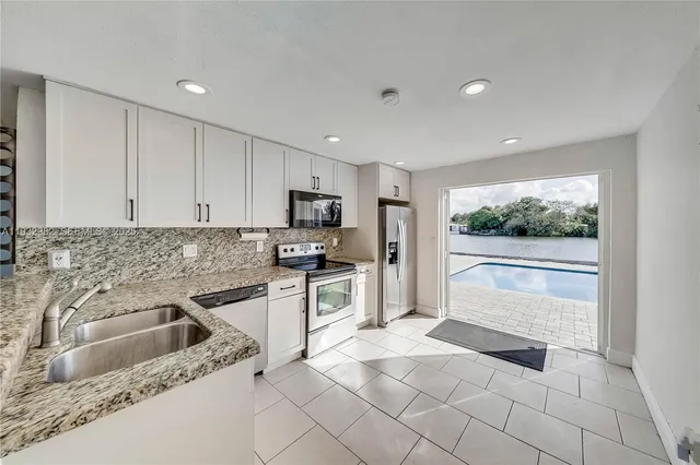 a kitchen with a sink a counter top space cabinets and stainless steel appliances