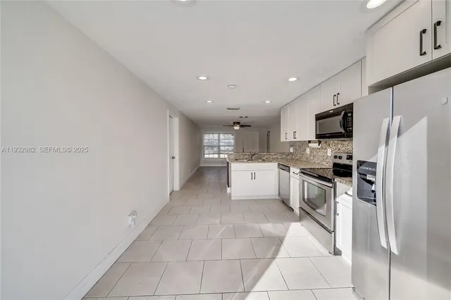 a large kitchen with cabinets and stainless steel appliances