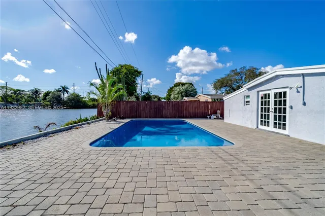 a view of a house with pool and a yard