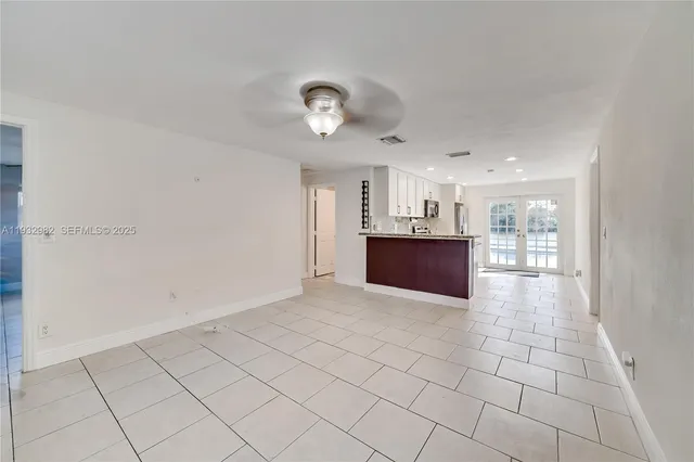 a big room with chandelier fan and windows