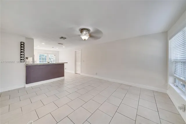 an empty room with cabinet and windows