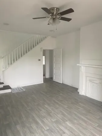 a view of a big room with carpet and a chandelier fan