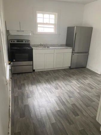 a view of a kitchen with wooden floor and electronic appliances