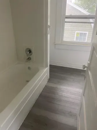 a bathroom with bathtub and window