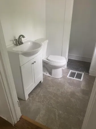 a bathroom with a sink a toilet and a mirror