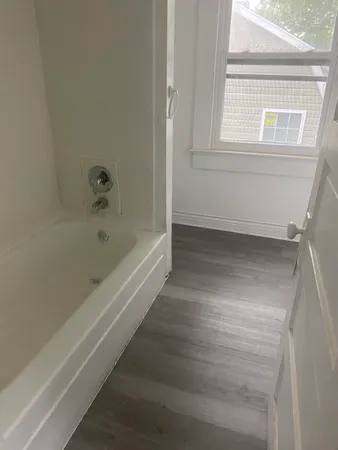 a bathroom with bathtub and window