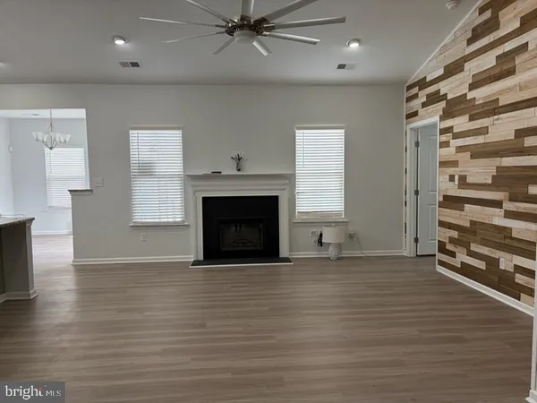 a view of an empty room with a window and fireplace
