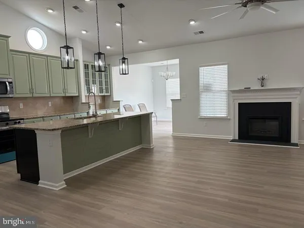 a kitchen with stainless steel appliances granite countertop a sink a stove and a wooden floors