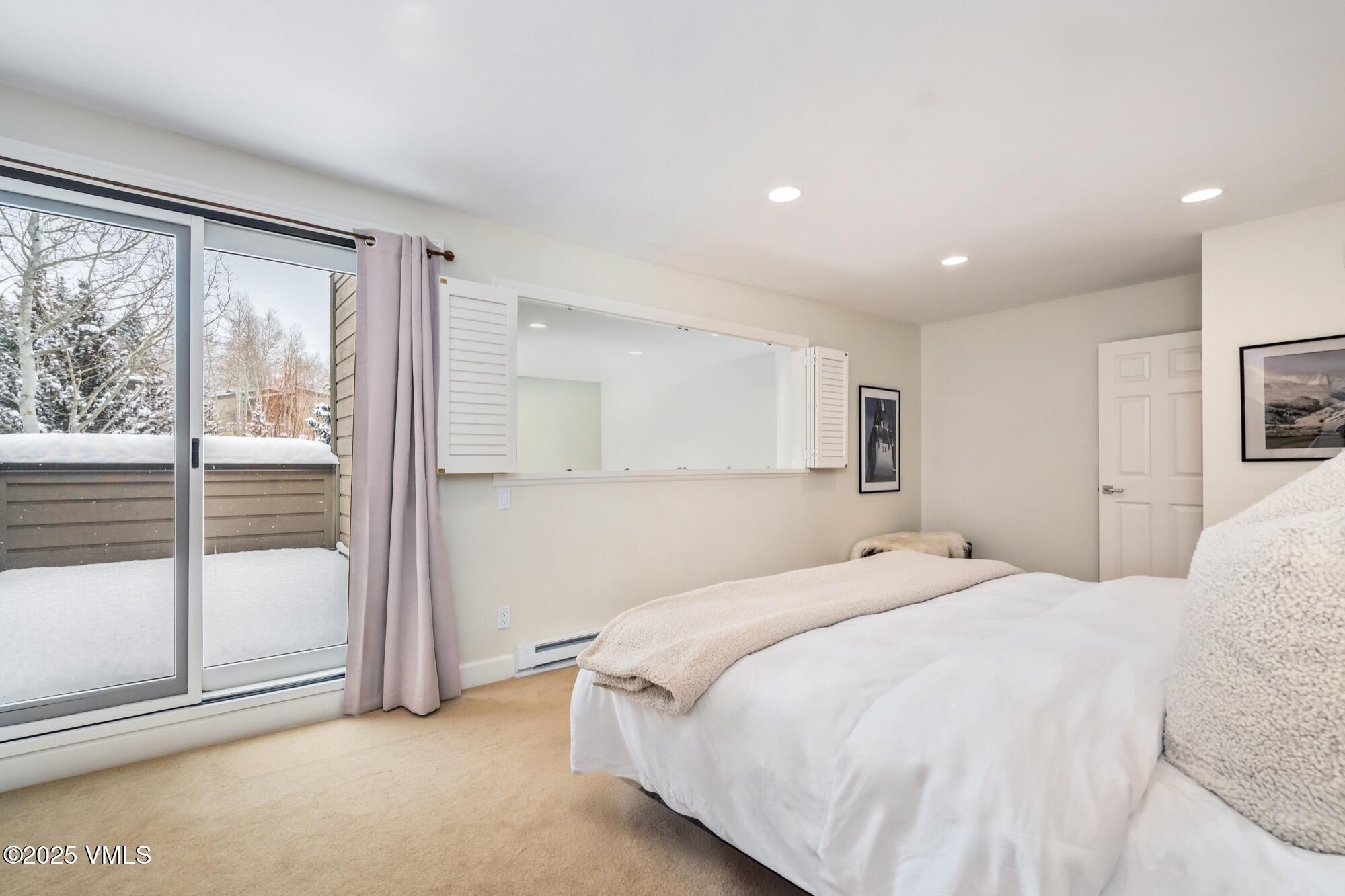 945 Red Sandstone Road, Unit A5 Vail, CO 81657 - Photo 19 of 38 a bedroom with a large bed and a large window