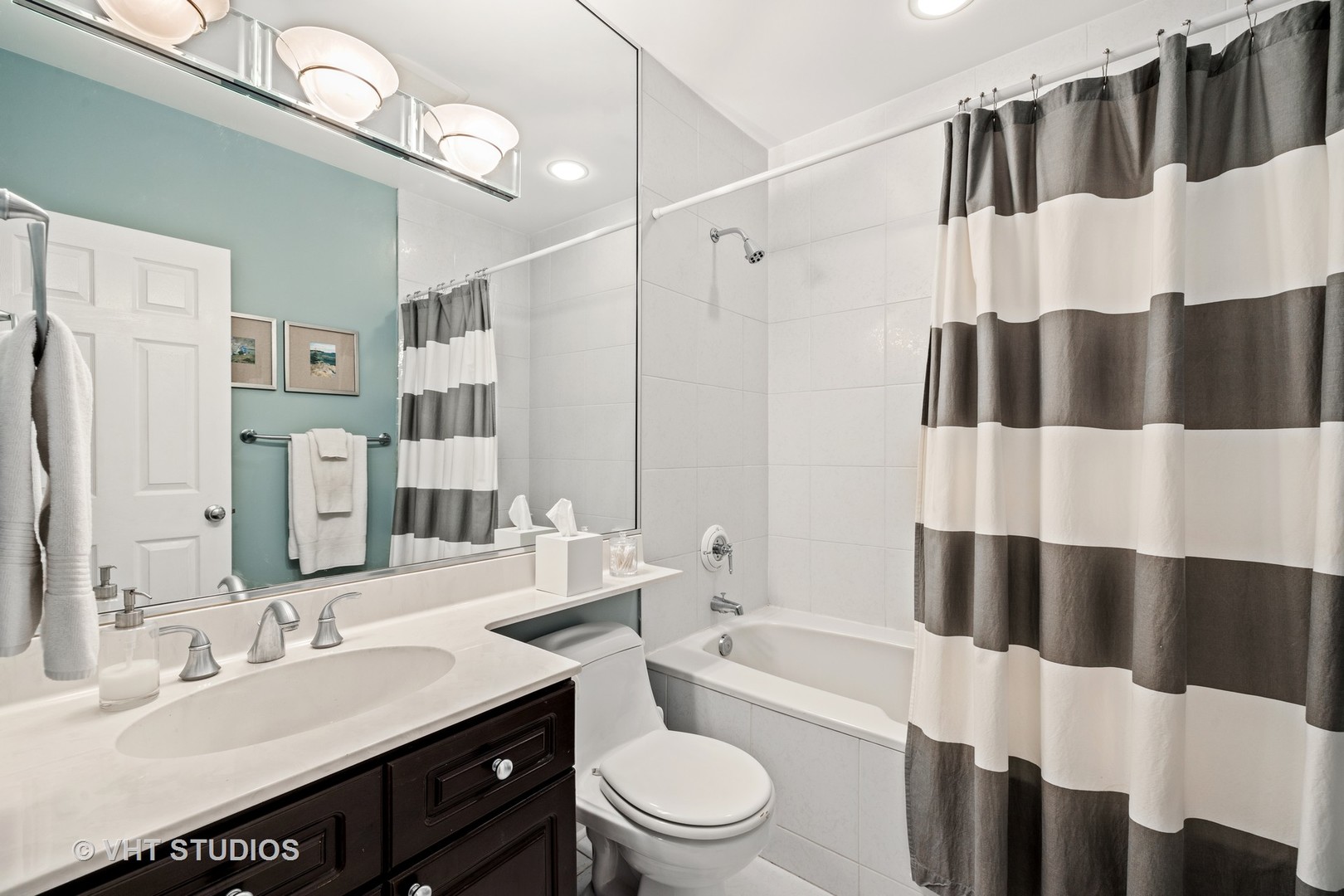 2050 North Racine Avenue, Unit 1 Chicago, IL 60614 - Photo 12 of 25 a bathroom with a sink a toilet a mirror a shower curtain and a large mirror
